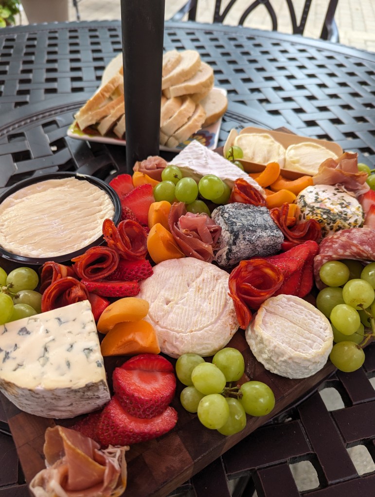 French cheese on a charcuterie board with lots of fruit
