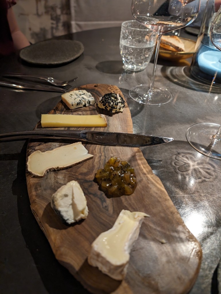 Cheese course on a rustic board at Qui Plume la Lune inParis